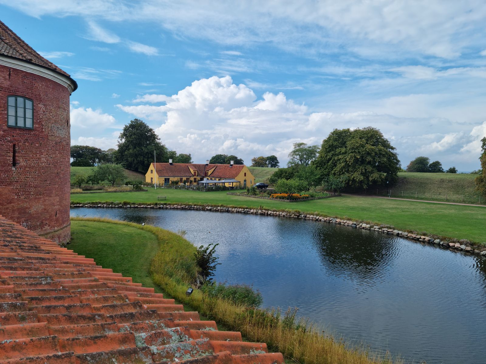 Dansk landskab med sø og hus i baggrunden